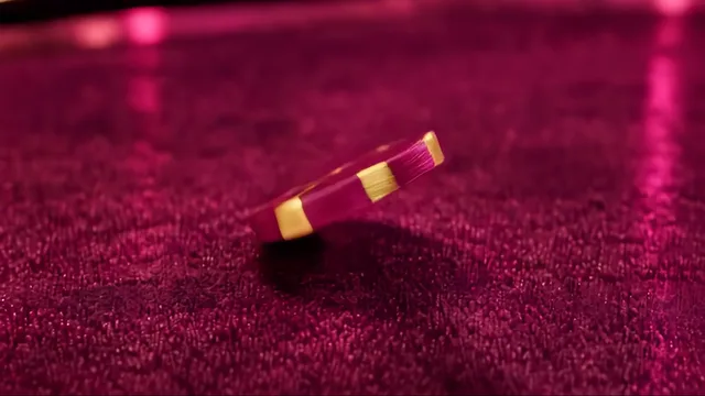 Un jeton de poker qui tourne sur la tranche sur le tapis rose